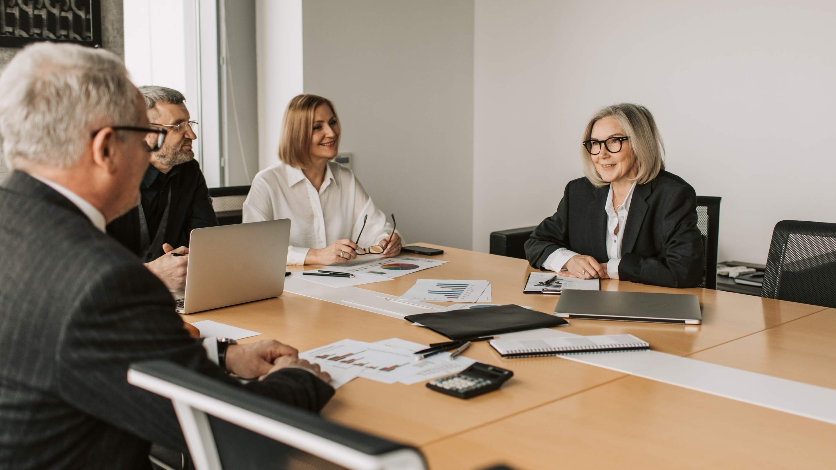Modern leadership, Executive team meeting discussing strategy and leadership decisions in a professional boardroom setting