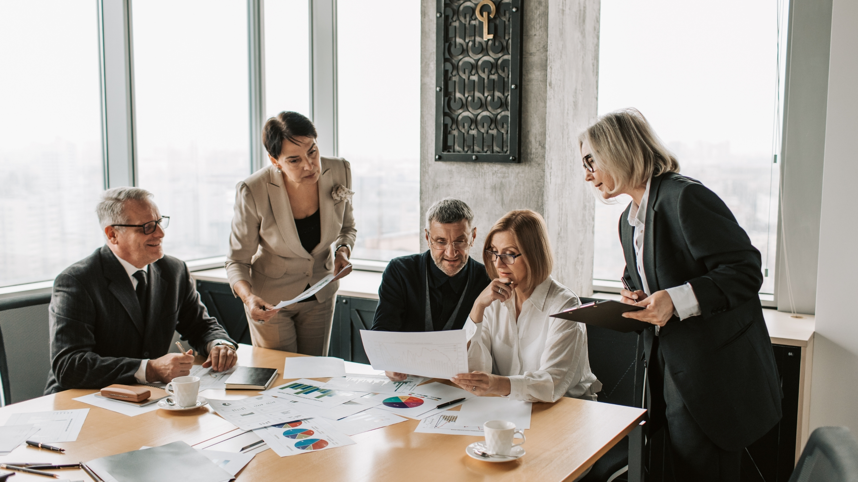Executive leadership team reviewing strategy and financial reports in a boardroom during economic uncertainty