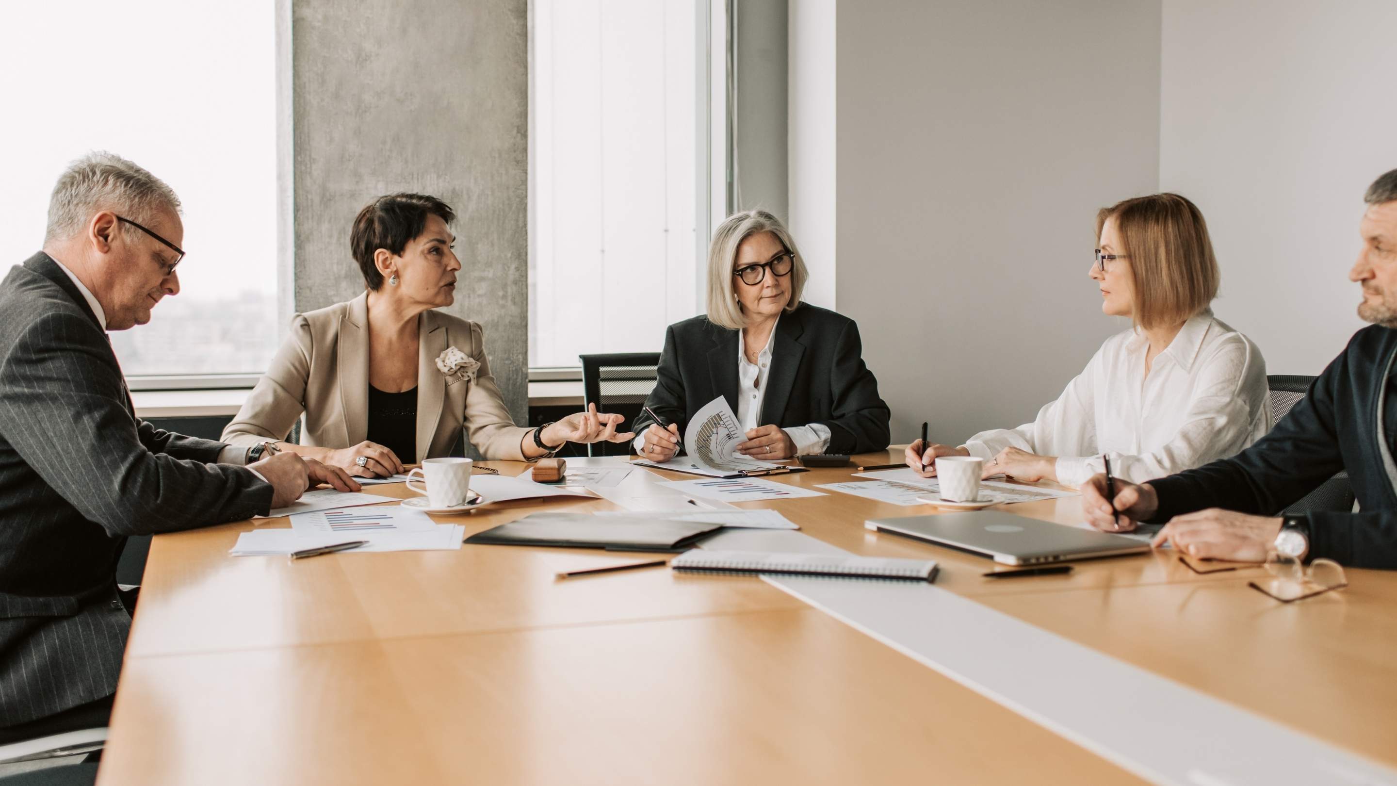 Nonprofit board members discussing executive hiring decisions and leadership strategy during a governance meeting in 2026